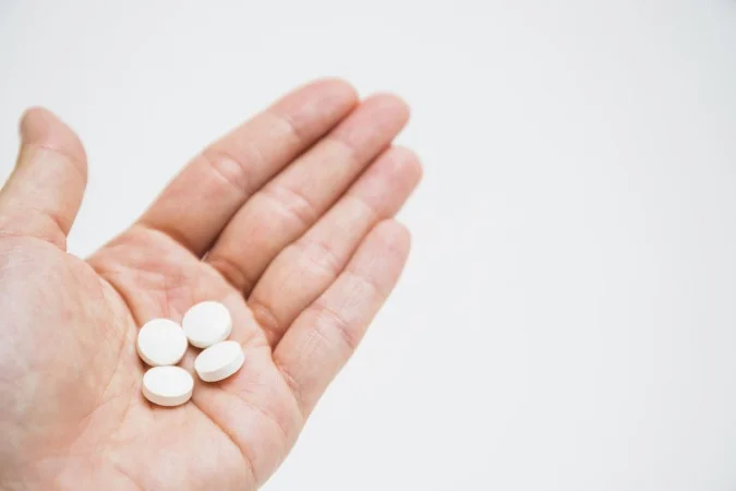 1_round-white-pills-hand-white-background-1-66850719