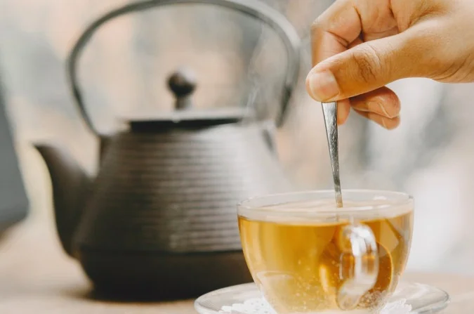 1_teapot_cup_hot_tea_table_hand_holding_teaspoon-50359026